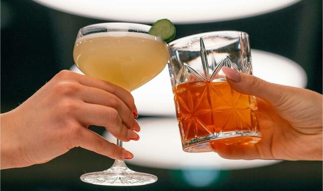 hands holding glasses with cocktails