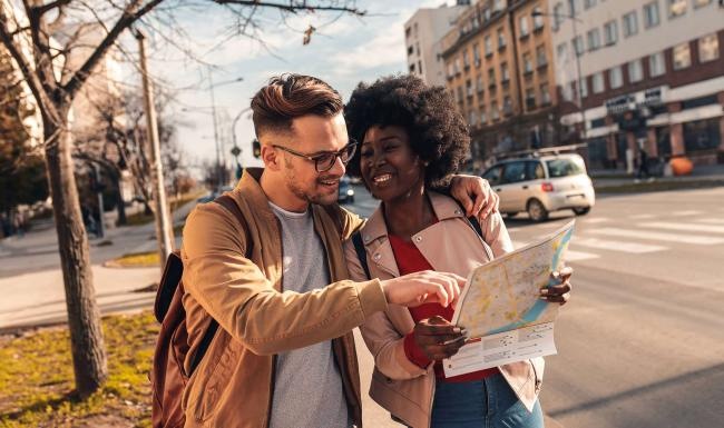 a man and woman looking at a map in the city